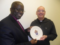 Archbishop Chama receives a Connor plate from Archdeacon Stephen McBride during his recent visit to Connor.
